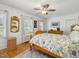 Cozy bedroom showcasing a ceiling fan, hardwood floors, and bright natural light from the window, with floral patterned bedding at 224 E Park Dr, Raleigh, NC 27605