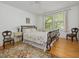 Cozy bedroom featuring hardwood floors, a floral bedspread, side tables, and natural light at 224 E Park Dr, Raleigh, NC 27605