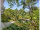 Scenic view of the lush front yard with a walkway, flowers, and mature trees, enhancing the property's curb appeal at 224 E Park Dr, Raleigh, NC 27605
