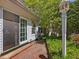 View of brick patio with siding door to the main house and manicured landscaping at 224 E Park Dr, Raleigh, NC 27605