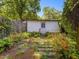 Quaint backyard with a shed and natural stone pathway amidst lush greenery at 224 E Park Dr, Raleigh, NC 27605