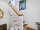 A classic staircase features white railings and wooden steps leading to the next floor, accented by a colorful painting at 224 E Park Dr, Raleigh, NC 27605