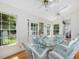 Bright sunroom with wood floors, glass table, and views of the yard at 224 E Park Dr, Raleigh, NC 27605