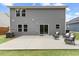 Relax on the concrete patio with comfortable wicker furniture, complemented by the home's gray siding and a well-maintained lawn at 230 Purple Aster St St, Youngsville, NC 27596