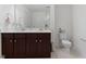 Well-lit bathroom featuring a double vanity with dark wood cabinets and a toilet, creating a functional space at 230 Purple Aster St St, Youngsville, NC 27596
