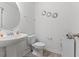 Bathroom with a pedestal sink, decorative mirrors, and a modern toilet, creating a stylish and functional space at 230 Purple Aster St St, Youngsville, NC 27596