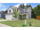 New two-story home showcasing gray siding, black shutters, a two-car garage, and a freshly landscaped lawn at 230 Purple Aster St St, Youngsville, NC 27596