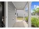 Cozy porch with gray siding, white support beams, modern lighting, and a glimpse of the neighborhood at 230 Purple Aster St St, Youngsville, NC 27596
