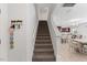Inviting staircase leading to an open living space with the kitchen and dining area in the background at 230 Purple Aster St St, Youngsville, NC 27596