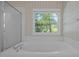Bright bathroom features a large tub under a window with natural light and patterned wallpaper at 2309 Clerestory Pl, Raleigh, NC 27615