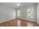 Light filled bedroom boasts hardwood floors, neutral paint, a ceiling fan, and two large windows at 2309 Clerestory Pl, Raleigh, NC 27615