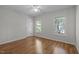 Light filled bedroom boasts hardwood floors, neutral paint, a ceiling fan, and two large windows at 2309 Clerestory Pl, Raleigh, NC 27615