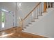 Welcoming foyer features hardwood floors and a staircase with white railings and wood trim at 2309 Clerestory Pl, Raleigh, NC 27615