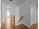 Hallway with hardwood floors and natural light leading to other rooms at 2309 Clerestory Pl, Raleigh, NC 27615