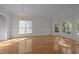 Inviting living room with abundant natural light from large windows, and polished hardwood floors at 2309 Clerestory Pl, Raleigh, NC 27615