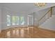 Bright, spacious living room featuring hardwood floors, large windows, and a classic chandelier at 2309 Clerestory Pl, Raleigh, NC 27615