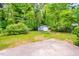 Lush backyard featuring mature trees, landscaping, shed and a charming wishing well feature at 2509 Elderwood Ln, Burlington, NC 27215