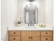 Bathroom with a modern arched mirror, light wood vanity, and natural stone countertop at 2509 Elderwood Ln, Burlington, NC 27215