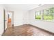 Bright bedroom with beautiful hardwood floors, fresh white paint, and a large window overlooking the backyard at 2509 Elderwood Ln, Burlington, NC 27215