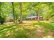A charming brick home with a well-maintained lawn and mature trees offers a serene and inviting curb appeal at 2509 Elderwood Ln, Burlington, NC 27215