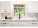 Bright kitchen featuring a sink with a view, white cabinetry, quartz countertops, and modern finishes at 2509 Elderwood Ln, Burlington, NC 27215