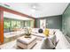 Open concept living space with hardwood floors, fireplace, and a bright sunroom visible beyond the couch at 2509 Elderwood Ln, Burlington, NC 27215