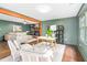 Open-concept living room with hardwood floors, a brick fireplace, and a sunroom with plenty of natural light at 2509 Elderwood Ln, Burlington, NC 27215
