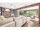 Bright living room with a brick fireplace, built-in shelving, and an adjacent sunroom filled with natural light at 2509 Elderwood Ln, Burlington, NC 27215