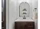 Stylish bathroom with a modern black framed arched mirror, and decorative shelving for storing bathroom accessories at 274 Tuscarora Ln, Clayton, NC 27520