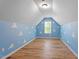 The blue bedroom features playful cloud accents, a large window, and wood laminate flooring at 274 Tuscarora Ln, Clayton, NC 27520