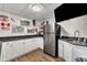 Basement kitchen with stainless steel appliances, white cabinets, and hardwood floors provides a convenient space for entertaining at 312 Grassy Point Rd, Apex, NC 27502