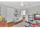 Bedroom with hardwood floors, a ceiling fan, and decorations on the wall at 312 Grassy Point Rd, Apex, NC 27502
