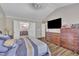 Bedroom with hardwood floors, TV, and access to the primary bathroom at 312 Grassy Point Rd, Apex, NC 27502