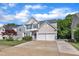 Charming two-story home features a two-car garage, blue shutters, and manicured lawn on a sunny day at 312 Grassy Point Rd, Apex, NC 27502