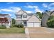Charming two-story home features a two-car garage, blue shutters, and manicured lawn on a sunny day at 312 Grassy Point Rd, Apex, NC 27502