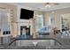 Close-up on granite countertops with a stainless steel sink and view to the living room fireplace at 312 Grassy Point Rd, Apex, NC 27502