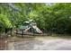Community playground with fencing offering a safe area for play, surrounded by trees, plus benches and picnic table at 312 Grassy Point Rd, Apex, NC 27502