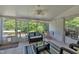 Bright sunroom with a ceiling fan, tiled flooring, and lots of windows to enjoy the outdoors from inside this cozy retreat at 312 Grassy Point Rd, Apex, NC 27502