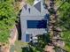 Aerial view of the home's roof, with solar panels, a lush backyard and a concrete patio at 3627 River Watch Ln, Franklinton, NC 27525