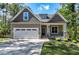 Charming craftsman-style home featuring a stone-accented porch and a two-car attached garage at 3627 River Watch Ln, Franklinton, NC 27525