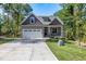 Attractive exterior view of a craftsman-style home with a two-car garage and stone detailing at 3627 River Watch Ln, Franklinton, NC 27525