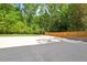 Newly constructed backyard concrete pad next to a privacy fence and green landscape at 3932 Old Chapel Hill Rd, Durham, NC 27707