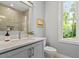 Well lit bathroom featuring a neutral paint color, large window, and a neutral color tiled shower at 3932 Old Chapel Hill Rd, Durham, NC 27707