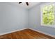 Bedroom featuring hardwood floors, base trim, and an exterior window offering views of the outside at 3932 Old Chapel Hill Rd, Durham, NC 27707