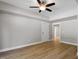 A neutral bedroom boasts hardwood floors and a modern ceiling fan with light fixture at 3932 Old Chapel Hill Rd, Durham, NC 27707