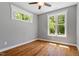 Bedroom featuring hardwood floors, neutral paint, white trim, and natural light from the exterior windows at 3932 Old Chapel Hill Rd, Durham, NC 27707