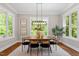 Bright dining room featuring a modern light fixture, large windows, and seating for six at 3932 Old Chapel Hill Rd, Durham, NC 27707