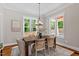 Sun-drenched dining room with hardwood floors, stylish chandelier, and ample natural light at 3932 Old Chapel Hill Rd, Durham, NC 27707