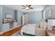 Comfortable main bedroom with soft blue walls, hardwood floors, and a ceiling fan at 3932 Old Chapel Hill Rd, Durham, NC 27707