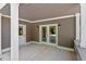Covered patio with French doors, neutral gray siding, and natural stone details at 3932 Old Chapel Hill Rd, Durham, NC 27707